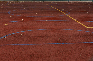 Wall Mural - Yellow and blue lines on the dark red sports ground as a background.Empty space