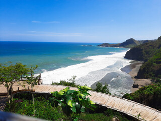 Surumanis beach, a beautiful blue beach with black sand and surrounded by hills