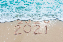 Message Year 2020 Replaced By 2021 Written On Beach Sand Background. Good Bye 2020 Hello To 2021 Happy New Year Coming Concept
