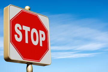 Closeup of a modern Stop Road Sign on blue sky with clouds and copy space.