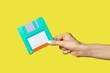 © Yaroslav Danylchenko/Stocksy - Paper craft diskette in the hand.