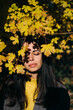 © Marc Bordons/Stocksy - Portrait of a brunette girl under dry leaves.