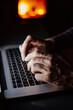 © Sergey Narevskih/Stocksy - Man working on laptop at night near fireplace