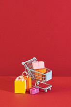 Annual Sale Shopping Season Concept - Mini Shop Cart Trolley Full Of Paper Bag Gift Isolated On Pale Pink Background, Blank Copy Space, Close Up