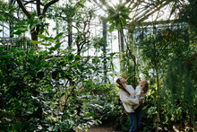 Mother And Daughter Walking In Greenhouse