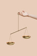 © Yaroslav Danylchenko/Stocksy - Woman's hand is holding the justice scale.