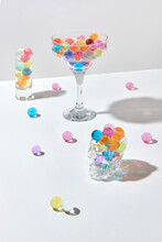 Glasses And Cups With Color Small Hydrogel Balls With Shadows.