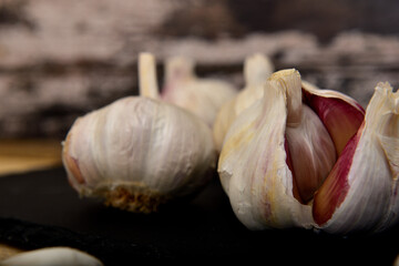 Wall Mural - Organic white garlic on a black slate plate