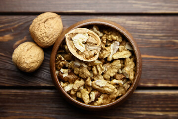 Wall Mural - Walnut half and seeds and bowl on wooden table