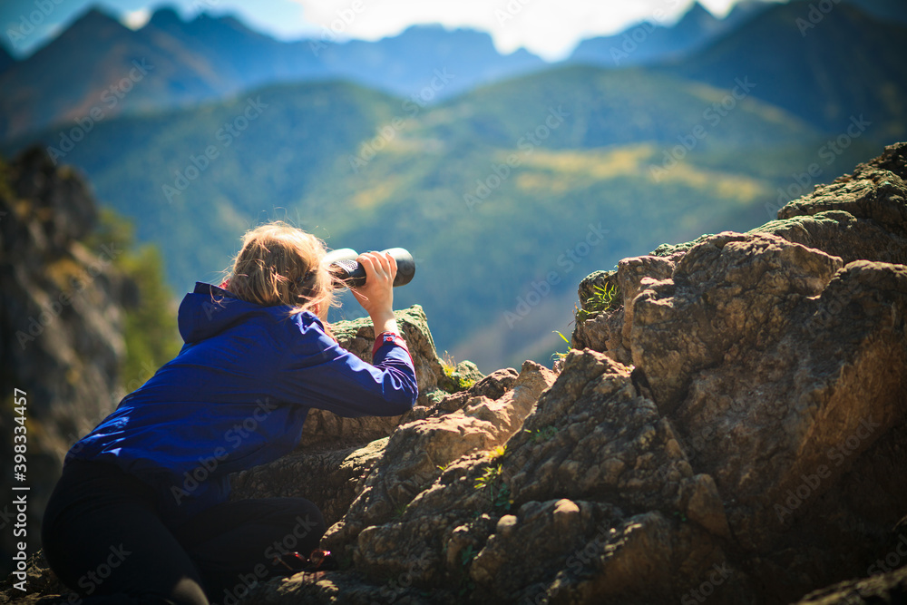 Obraz na płótnie Młoda dziewczyna obserwuje odległe górskie szczyty przez lornetkę, Tatry, Polska w salonie