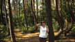 Zachwycona dziewczyna podziwia pomnik przyrody o nazwie Krzywy Las znajdujący się w województwie Zachodniopomorskim nieopodal miejscowości Nowe Czarnowo, Polska