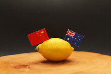 Australian And Chinese Flags Poking Out Of A Lemon On A Chopping Block Representing The Strained Soured Relationship And Trade War Being Waged Between The Two Countries.