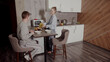 © iaginzburg - A woman serves a man at Breakfast. She brings him food on plates and puts cornflakes in the milk. The issue of gender inequality.