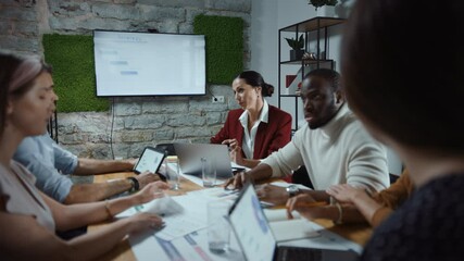 Wall Mural - Diverse Multi-Ethnic Team of Professional Businesspeople Meeting in the Modern Office Conference Room. Creative Team Around Table Discuss, Negotiate, Plan Marketing Compain, Social Media Strategy