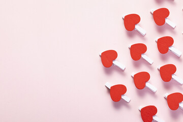 Poster - Shot of red hearts on clothespins arranged on the part of the pink background