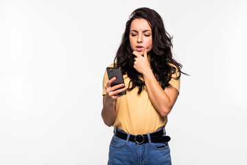 Wall Mural - Thinking woman with phone in hand isolated on white background