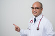 © Chanakon - Doctor in white coat, stethoscope pointing finger to beside look into camera.with smile and tilt standing isolated on white background.