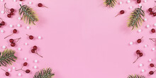 Banner With Seasonal Red Winter Berries, White Snowballs And Fir Branches On Sides Of Light Pink Background With Empty Copy Space In Middle