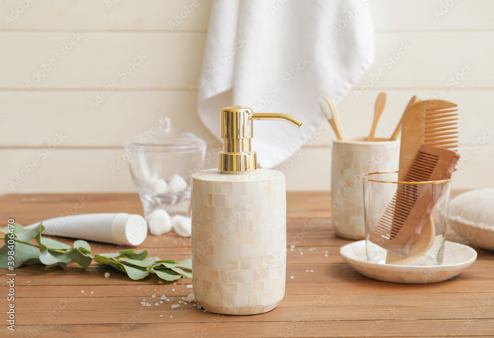 Dispenser and set of bath accessories on wooden table