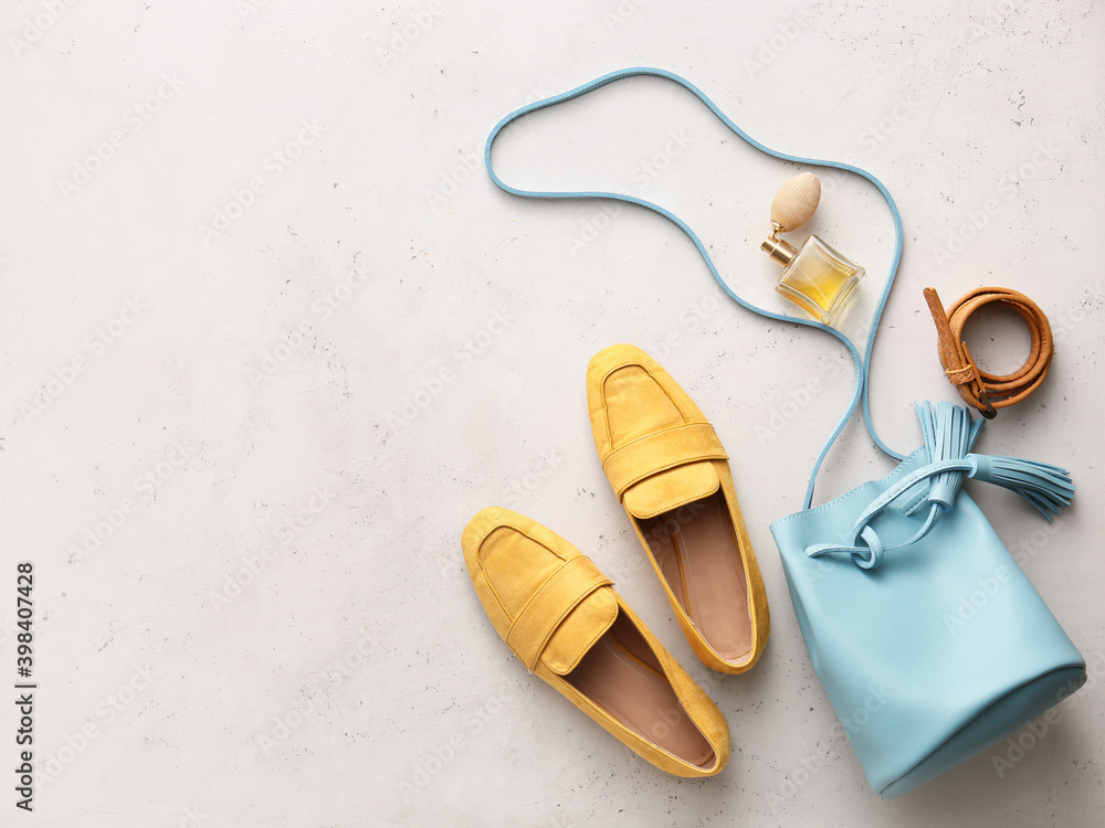 Stylish bag, accessories and shoes on light background