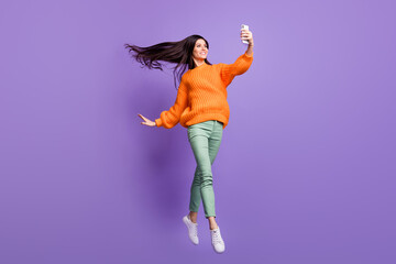 Wall Mural - Full length body size photo of jumping ballerina smiling taking selfie on smartphone isolated on bright violet color background