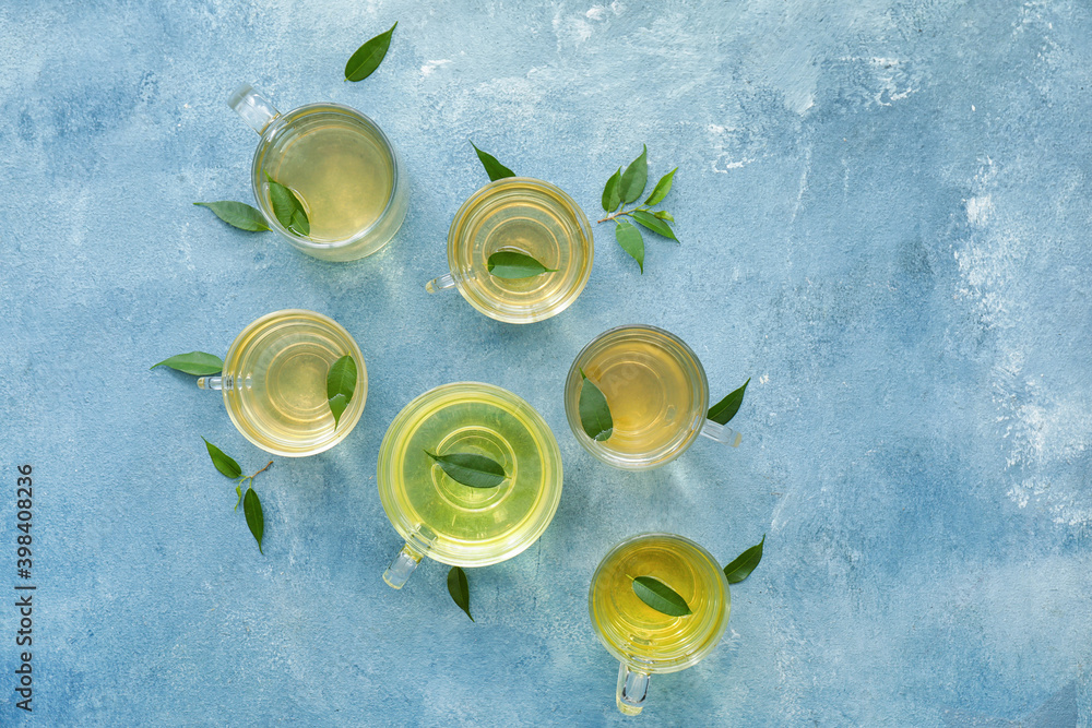Cups of green tea on color background
