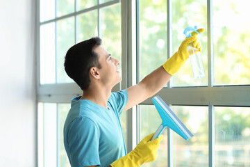 Poster - Young man cleaning window at home