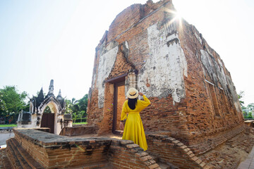 Young Asian woman tourist travel in the old Temple in Thailand.