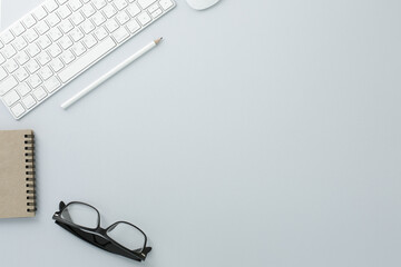 Glasses mouse pencil keyboard and notepad on white background