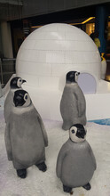 Group Of Penguine Sculptures In Front Of An Igloo