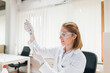 © bnenin - Female scientist with dropper or pipette examining sample.