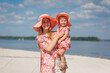 © Kate - A charming girl in a light summer sundress walks on the sandy beach with her little daughter. Enjoys warm sunny summer days