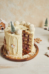 Poster - Vertical shot of a delicious Christmas cake with gingerbread decorations and coconutâ€“almond ball