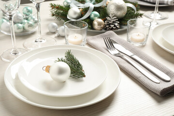 Festive table setting with beautiful dishware and Christmas decor on white wooden background