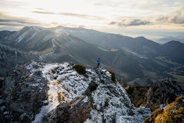 Wall Mural - Hiker with backpack standing on top of a mountain and enjoying view. Adventure concept