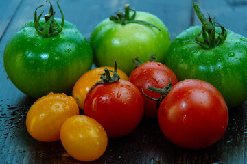 Sticker - High angle shot of wet ripe and unripe tomatoes on a wooden table