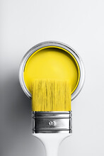 Demonstrating Colors Of Year 2021 - Gray And Yellow. Brush With White Handle On Open Can Of Yellow Paint On Monochrome Background.