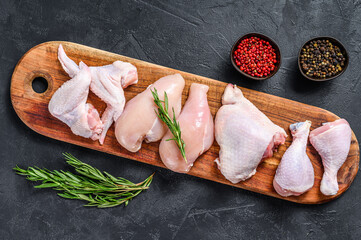 Fresh raw chicken meat and chicken parts. Black background. Top view