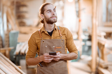 Wall Mural - Carpenter with phone in the workshop