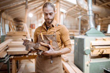 Wall Mural - Handsome carpenter with vintage working tools in the carpentry workshop