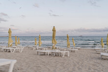 Beach Umbrellas And Deck Chairs On Empty Beach At Dusk
