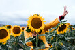 © Eva Blanco/Westend61 - Young woman hiding behind sunflower in sunflower field