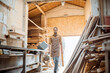 © rh2010 - Old wood storage with pile of boards and carpenter on the background at the carpentry