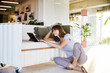 © Jo Kirchherr/Westend61 - Smiling mature woman with hands in hair using digital tablet while sitting at home