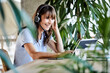 © Jo Kirchherr/Westend61 - Smiling woman with headphones using digital tablet while sitting by table at home