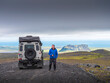 © Albrecht Wei√üer/Westend61 - Male tourist looking away while standing by off-road vehicle on road against cloudy sky