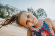 © Mareen Fischinger/Westend61 - Little girl smiling while standing at beach
