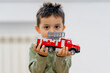 © Oscar Carrascosa Martinez/Westend61 - Cute boy holding fire engine toy at home