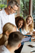 © peter scholl/Westend61 - Business people working together while sitting in meeting at office