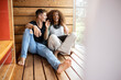 © peter scholl/Westend61 - Cheerful young couple with digital tablet sitting on floor at home